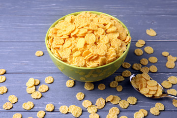 Bowl with cornflakes on grey wooden background