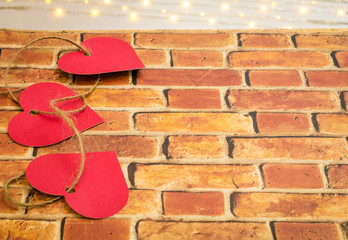 Valentine hearts interwoven with hemp twine on bricks and bokeh lights with room for text