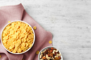 Bowl with cornflakes and napkin on wooden table