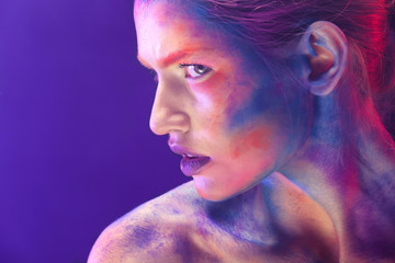 Portrait of young woman with bright body-art in smoke, closeup