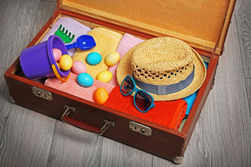 Easter eggs with open suitcase on floor