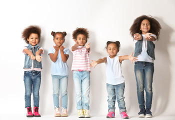Fototapeta premium Five cute African girls sending kiss on white background