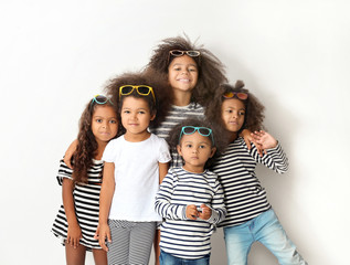 Five cute African girls in striped clothes on white background