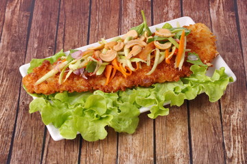Spicy deep-fried Dolly's fish salad with roll green mango.