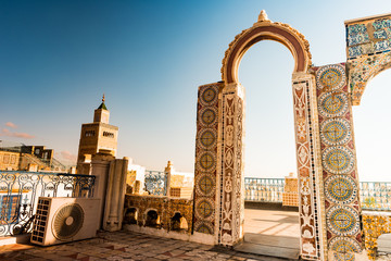 Detail of traditional arabic architecture in cityscape at dawn with dramatic sunlight. Tunisia, North africa.