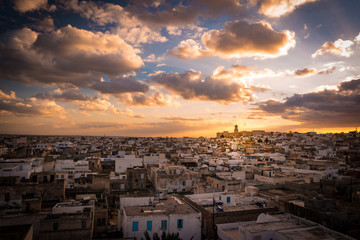 View of the Medina and the castle kasbah in Sousse, Tunisia. Cityscape of Sousse at dramatic sunset with red skies and clouds.