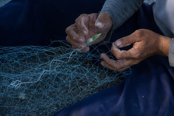 man making fishing net