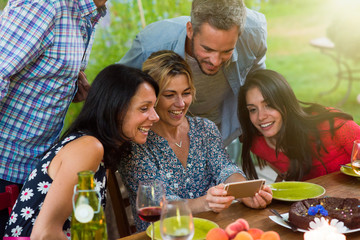 Group of friends having fun by watching photos on a smartphone