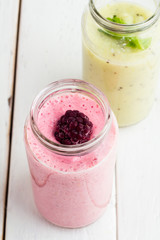 Pink smoothies and green smoothies on a white table top view