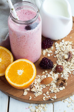 pink smoothie, oatmeal, nuts, oranges closeup