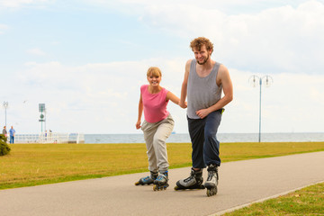 Fototapeta premium Man encourage woman to do rollerblading