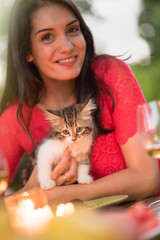 Beautiful brunette woman with a lovely little cat in arms