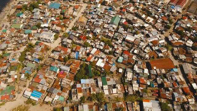 Aerial view poor district of Manila's slums, ghettos, wooden old houses, shacks. Aerial footage slum area of Manila, Philippines. Manila suburb, view from the plane. 4K video.