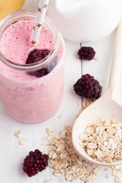 blackberry smoothies and ingredients on a white wooden background close-up