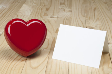 Red heart beside white blank card. Valentines and Love concept.