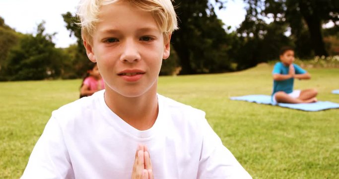 Portrait of boy performing yoga in park on a sunny day 4k
