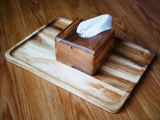 tissue paper in wooden box holder on wooden tray and floor