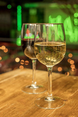White and red wine glasses on blurred lights background