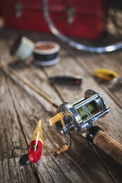 antique fishing lures, rod, and reel on a wood table