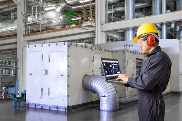 Engineer using laptop computer for maintenance in powerhouse