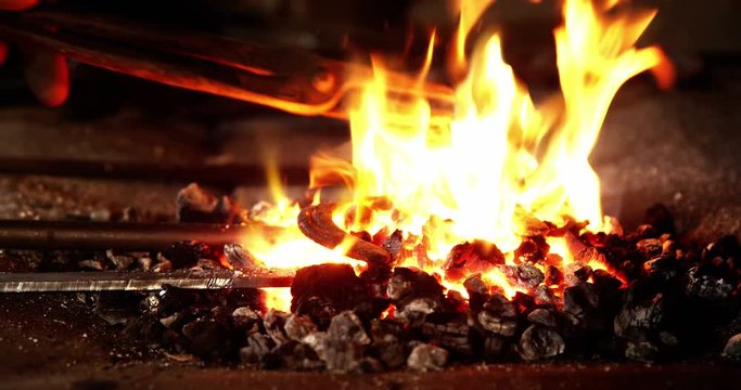 Close-up of blacksmith heating a horseshoe in fire 4k