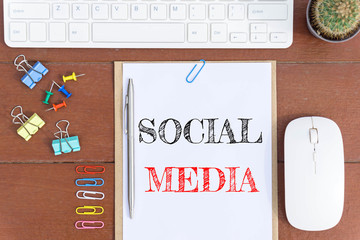 Text Social media on white paper which has keyboard mouse pen and office equipment on wood background / business concept.