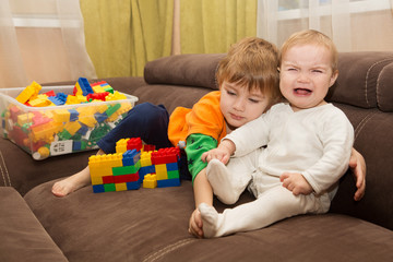  two kids conflict for plastic blocks constructor indoor. the ki