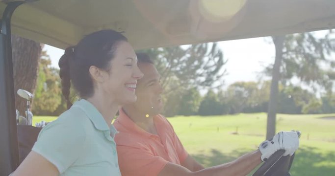 Two golfers driving in their golf buggy at golf course