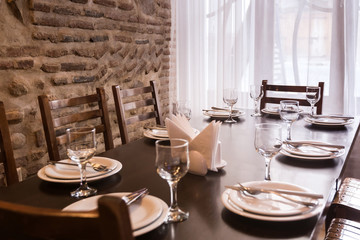 Served table in a restaurant. Focus on near glass and plate