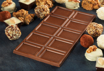 Bar milk chocolate close up on dark stone surface