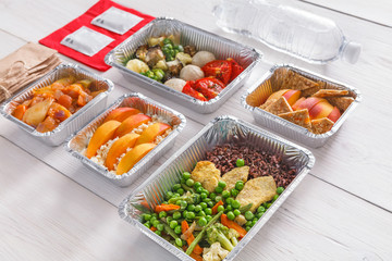 Healthy food take away in boxes, top view at wood