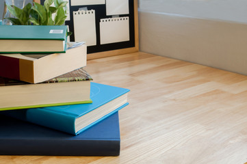 Naklejka premium Closeup Stack of colorful books on wooden table with blackboard. Time to learn and read concept.