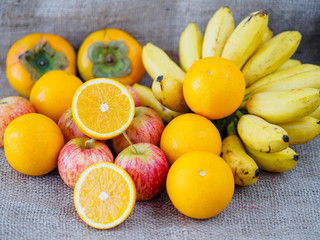 fruits apples oranges banana plums on brown hemp sack texture background