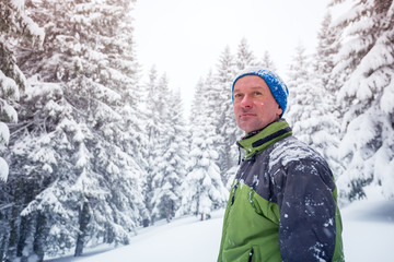 Fototapeta na wymiar Portrait of happy man in the winter mountains