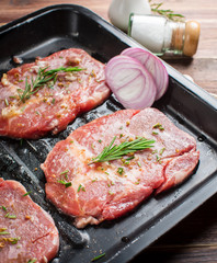 Raw fresh meat steak with rosemary leaves and salt on wood