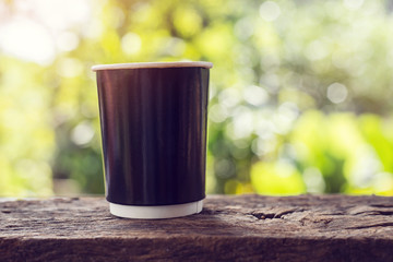 A cup of coffee on wooden table with bokeh background