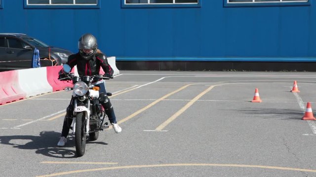 Learner motorcyclist trying to start driving on motorbike in driver school
