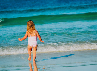 Fototapeta premium little girl going to swim at beach