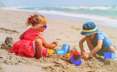 kids play with sand on summer beach
