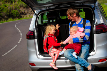 father with two little kids travel by car in nature