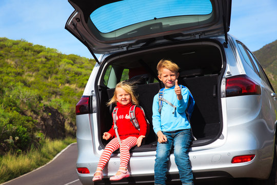 Little Boy And Girl Travel By Car On Road In Nature