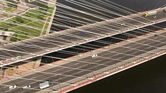 Multi lane highway (KAD) with driving vehicles at cable-stayed Bolshoy Obukhovsky Bridge. Aerial view. Neva river, St. Petersburg, Russia
