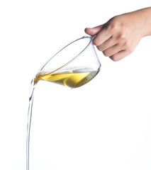 Pouring cooking oil from measuring cup isolated on white
