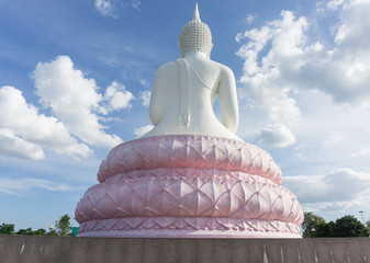 White Buddha statue on blue sky.