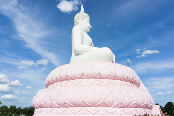 White Buddha statue on blue sky.