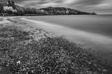 Landscape on the autumn coast. Stormy weather. Long exposure shot. Black and white photo.