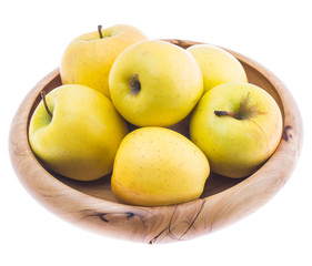 big ripe juicy yellow golden apples in wooden bowl isolated on white background