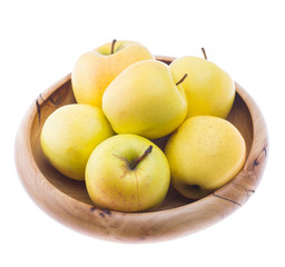 big ripe juicy yellow golden apples in wooden bowl isolated on white background