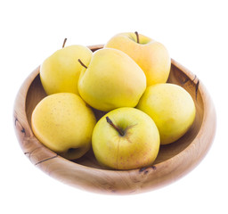 big ripe juicy yellow golden apples in wooden bowl isolated on white background