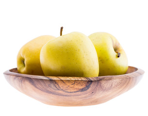 big ripe juicy yellow golden apples in wooden bowl isolated on white background